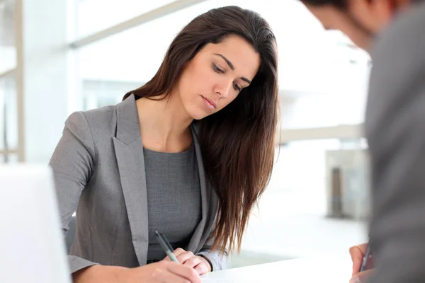 Zakenvrouw schrijven op document na vergadering — Stockfoto