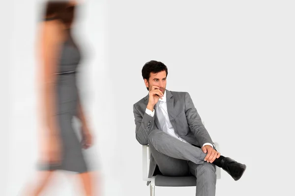 Hombre de negocios sentado en la sala de espera y mujer caminando por —  Fotos de Stock