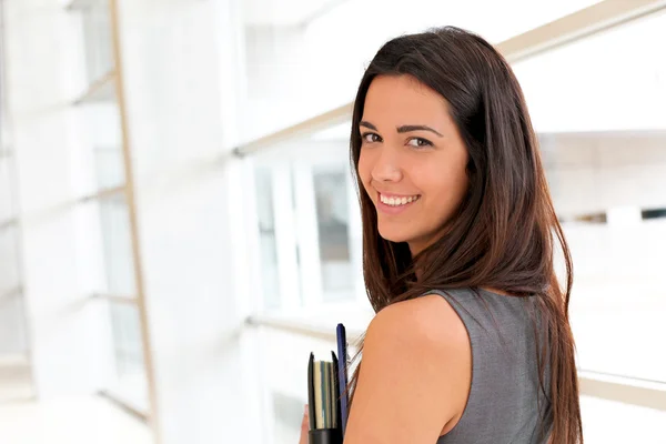 Young businesswoman in modern building holding files — Stock Photo, Image