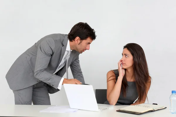 Homme d'affaires au bureau harcelant jeune femme — Photo