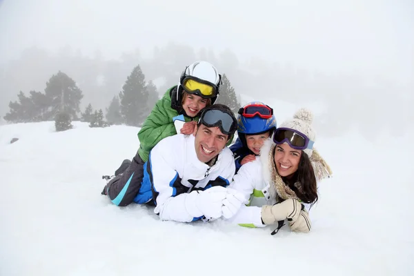 Щаслива сім'я лежить на снігу — стокове фото