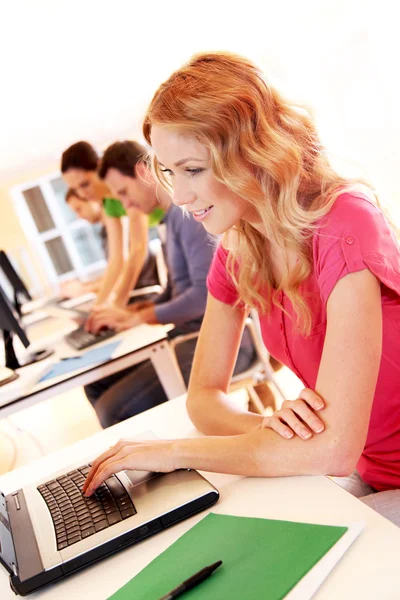 Prachtige blond meisje op laptopcomputer werkt — Stockfoto