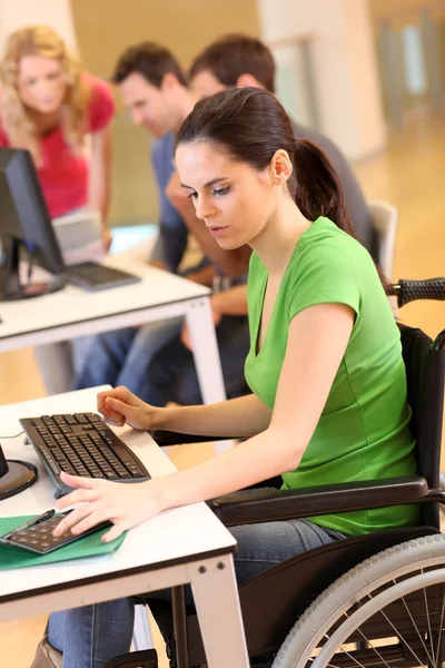 Jonge vrouw in rolstoel werken in office — Stockfoto