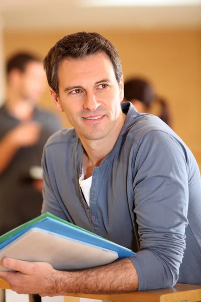 Portrait of man standing in building hall with files — Stock Photo, Image