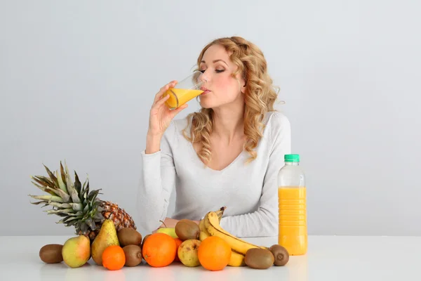 Ελκυστική ξανθιά γυναίκα πίνοντας χυμό πορτοκαλιού — Φωτογραφία Αρχείου