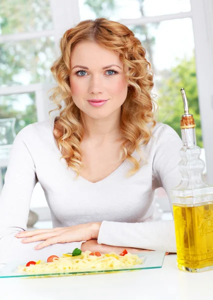 パスタの皿によって座っている金髪の女性の肖像画 — ストック写真