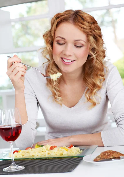 Woman eating pasta for dinner — Stok fotoğraf