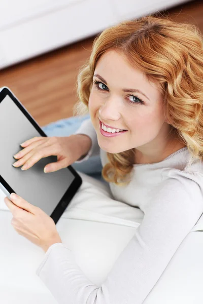 Mujer rubia relajándose en el sofá usando tableta electrónica — Foto de Stock