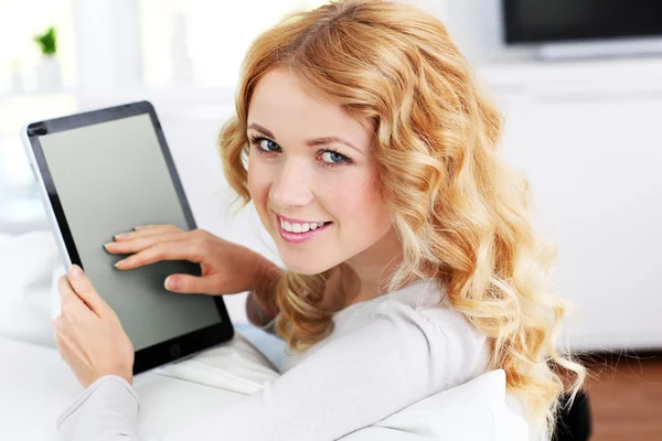 Mujer rubia relajándose en el sofá usando tableta electrónica — Foto de Stock