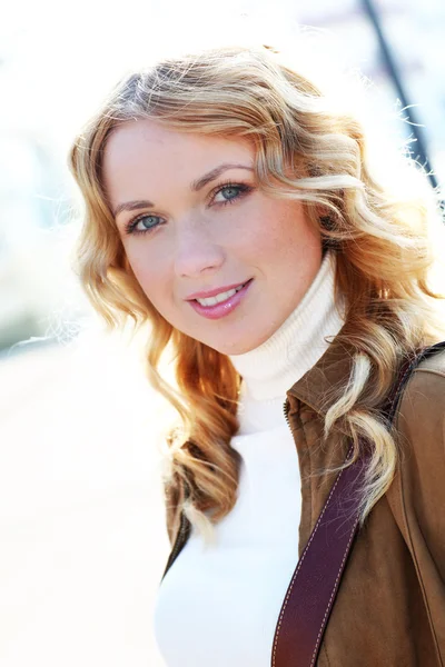 Beautiful blond woman in town by sunny day — Stock Photo, Image