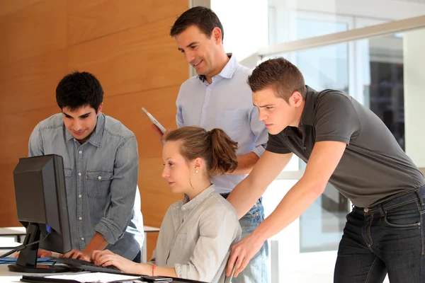 Groupe d'étudiants avec professeur travaillant sur ordinateur — Photo