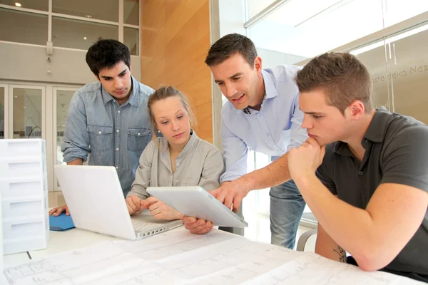 Pädagoge mit Architekturstudenten, die an einem elektronischen Tablet arbeiten — Stockfoto