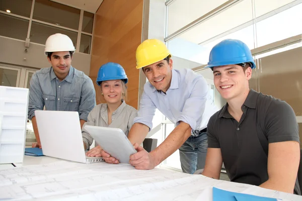 Educatore con studenti in architettura che lavorano su tablet elettronico — Foto Stock