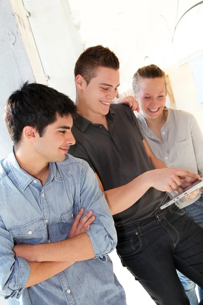 Amigos en el pasillo escolar usando tableta electrónica —  Fotos de Stock