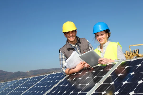 Hombre mostrando paneles solares tecnología a estudiante chica — Foto de Stock