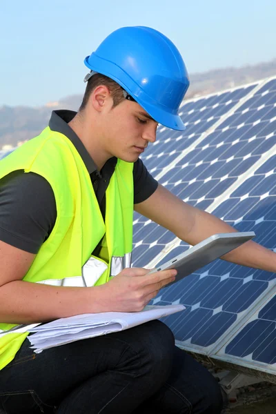 Jovem adulto fazendo treinamento profissional em planta de painéis solares — Fotografia de Stock