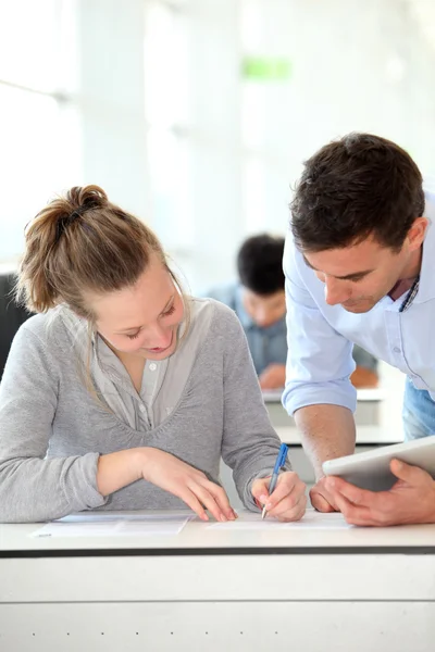 Lärare med student tjej skrivuppgift — Stockfoto