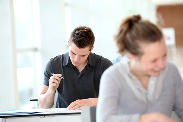 Student ve třídě psaní přiřazení — Stock fotografie