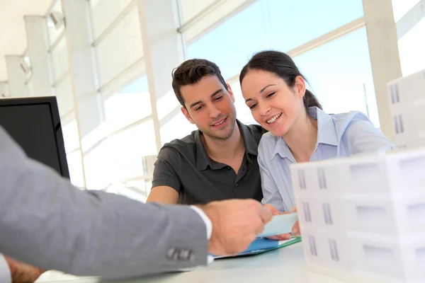 Couple in real-estate agency signing property loan contract — Stock Photo, Image