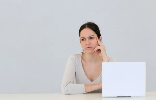 Mujer joven frente a la computadora portátil aislado — Foto de Stock