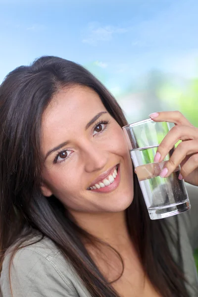 Portrait of smiling woman holding glass of water — Stock Photo, Image