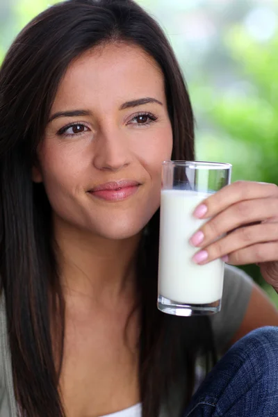 Jonge vrouw die melk drinkt — Stockfoto