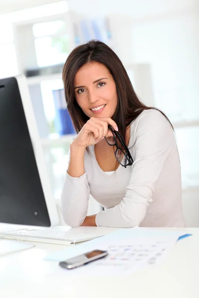 Beautiful office worker in front of desktop computer — Stock Photo, Image