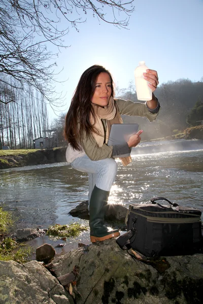 Mulher testando a qualidade da água natural — Fotografia de Stock