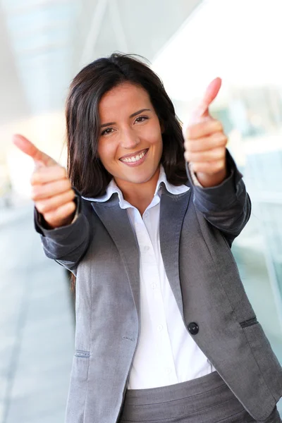 Alegre mujer de negocios mostrando tumbas hasta — Foto de Stock