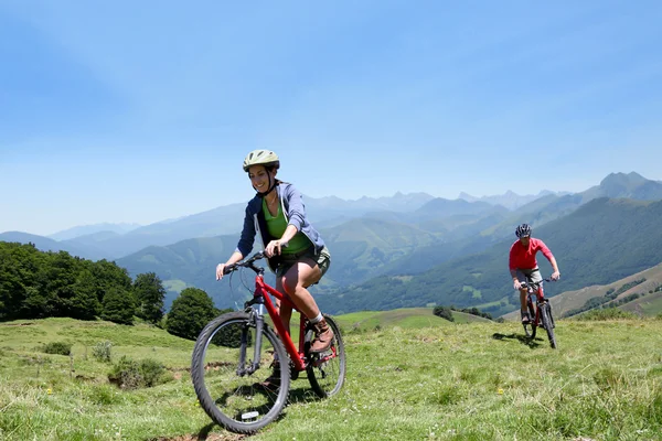 Pareja de bicicletas de montar en las montañas — Foto de Stock