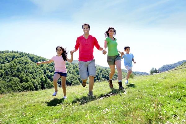 Família feliz desfrutando e correndo juntos nas montanhas — Fotografia de Stock
