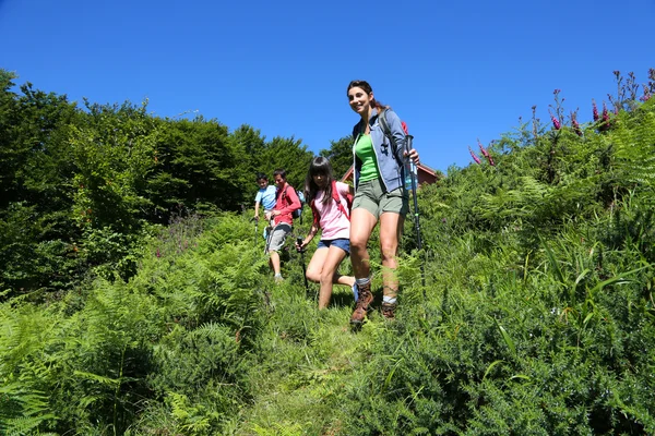 Família em um dia de caminhada descendo colina — Fotografia de Stock