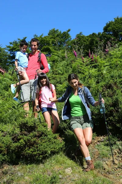 Família em um dia de caminhada descendo colina — Fotografia de Stock