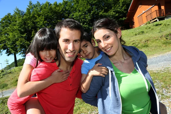 Ouders en kinderen staande aan de voorkant van de berg blokhuis — Stockfoto