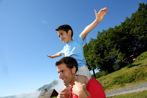 Папа носит сына на плечах
