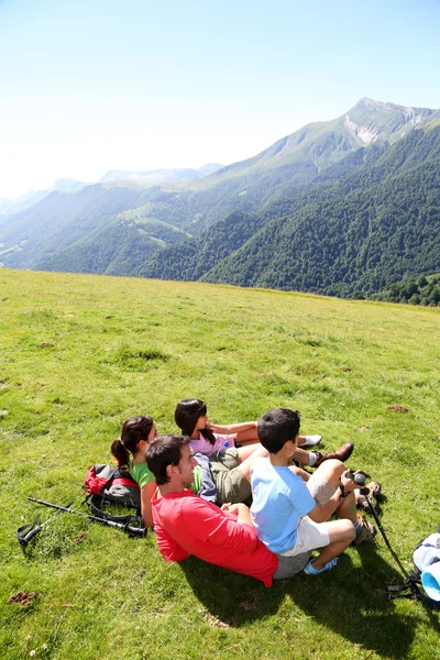 Família que estabelece a grama desfrutando de vista montanha — Fotografia de Stock