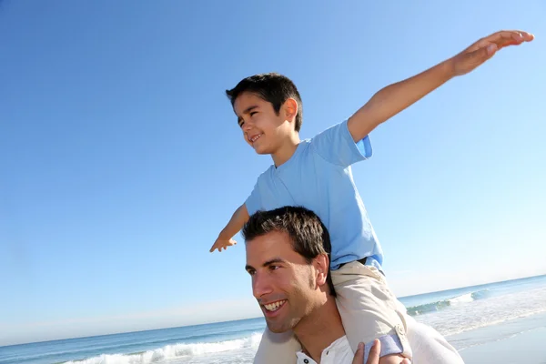 Vater hält Sohn am Strand auf den Schultern — Stockfoto