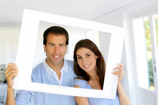 Primer plano de pareja alegre mirando a través del marco —  Fotos de Stock