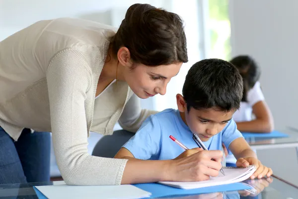 Lehrer hilft kleinem Jungen bei Schreibstunde — Stockfoto