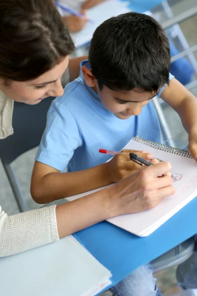 Enseignant aidant jeune garçon avec la leçon d'écriture — Photo