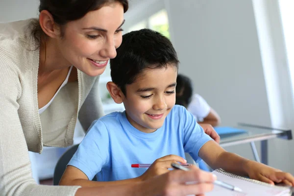 Leraar jongen helpen met het schrijven van Les — Stockfoto