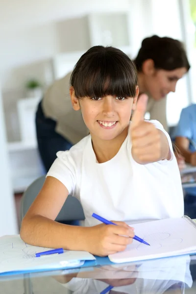 Gros plan de la petite fille en classe montrant pouce vers le haut — Photo