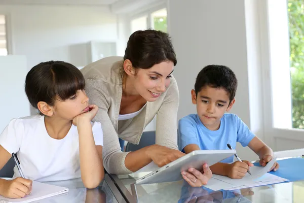 Donna che insegna ai bambini delle scuole con tablet digitale — Foto Stock