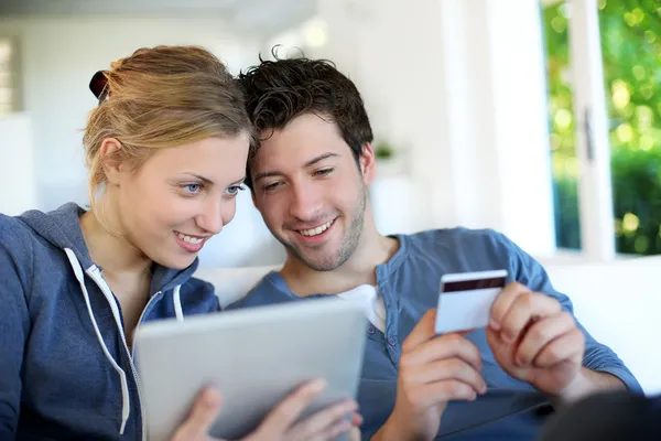 Happy young couple doing shopping on internet — Stock Photo, Image