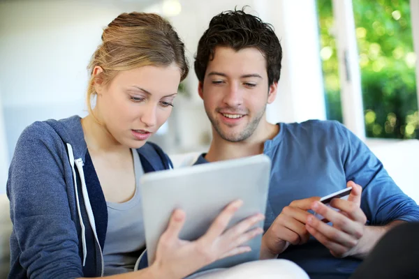 Happy young couple doing shopping on internet — Stock Photo, Image
