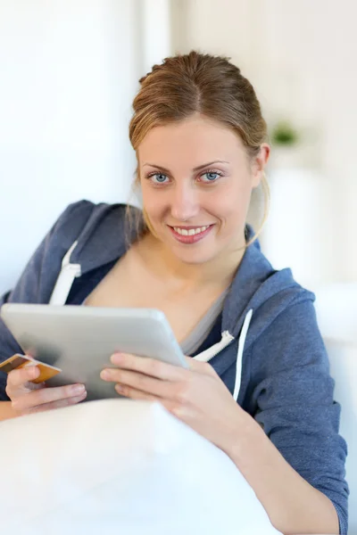 Student sedí v sofa s digitálním tabletu — Stock fotografie