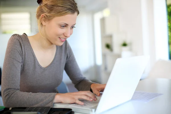 Wanita muda cantik belajar di rumah pada laptop — Stok Foto