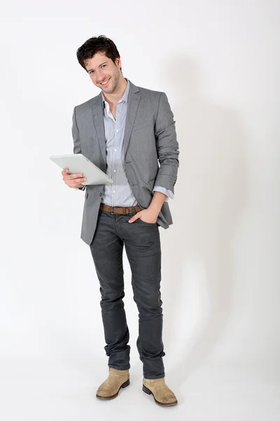 Young man standing on white background with tablet — Stock Photo, Image