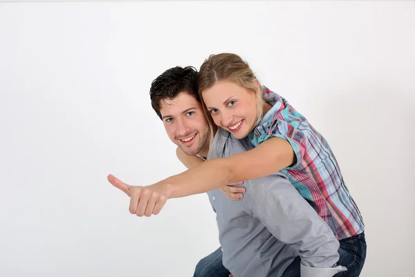 Young man carrying girlfriend on his back — Stock Photo, Image