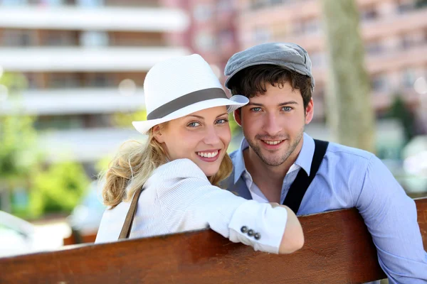 Szép fiatal pár ül a padon finom állami — Stock Fotó
